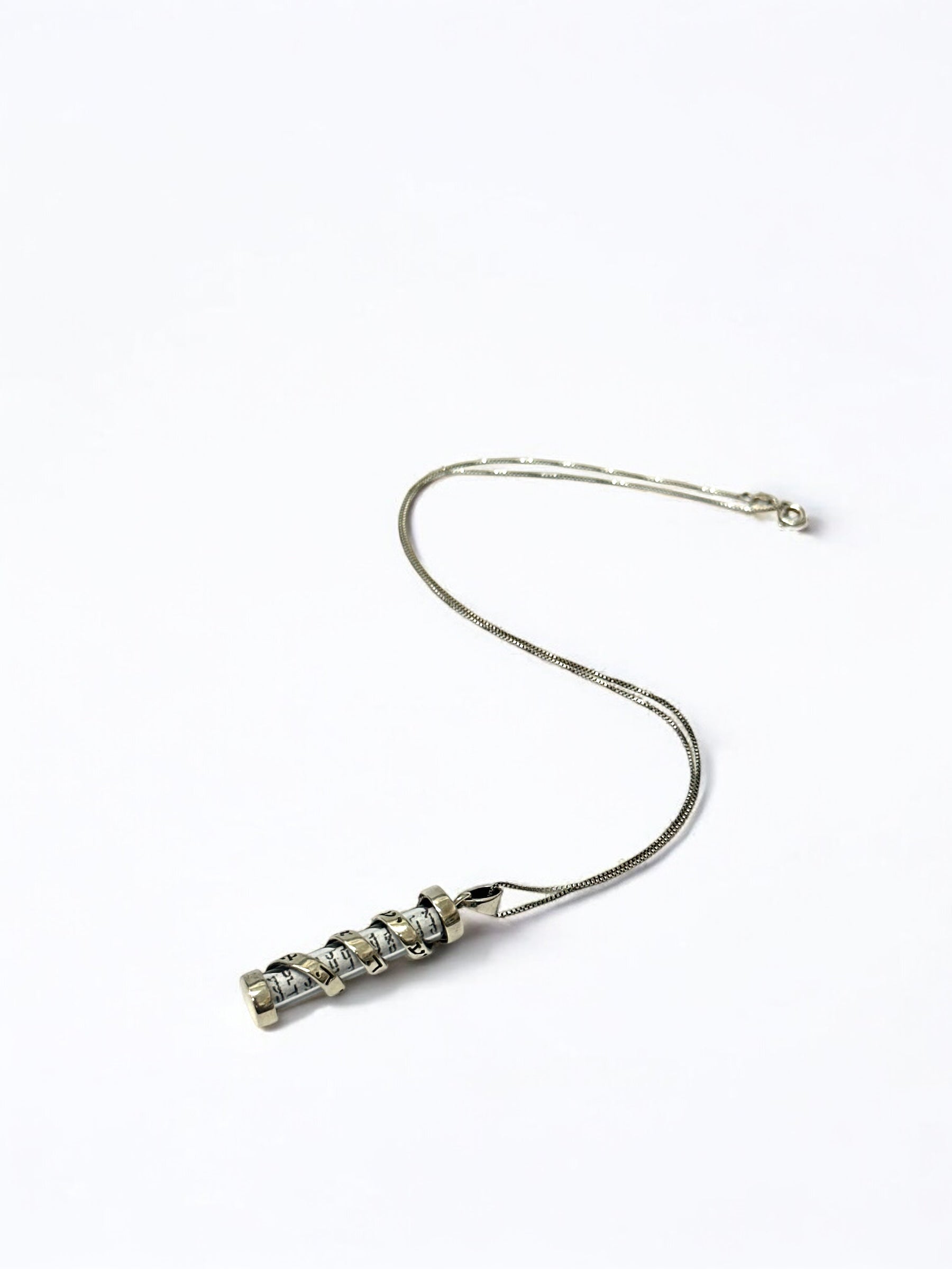 Close-up of Hebrew scripture text on mezuzah pendant