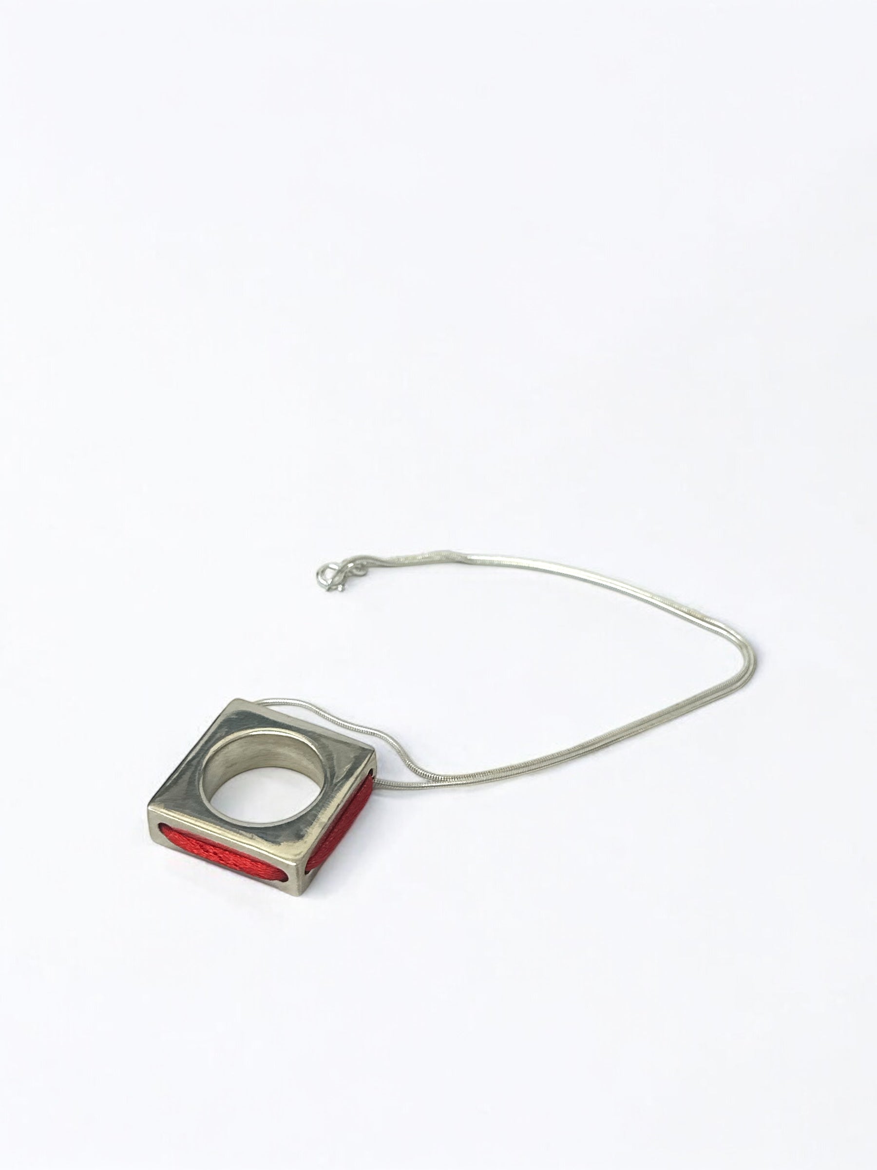 Close-up of red string ring pendant detail