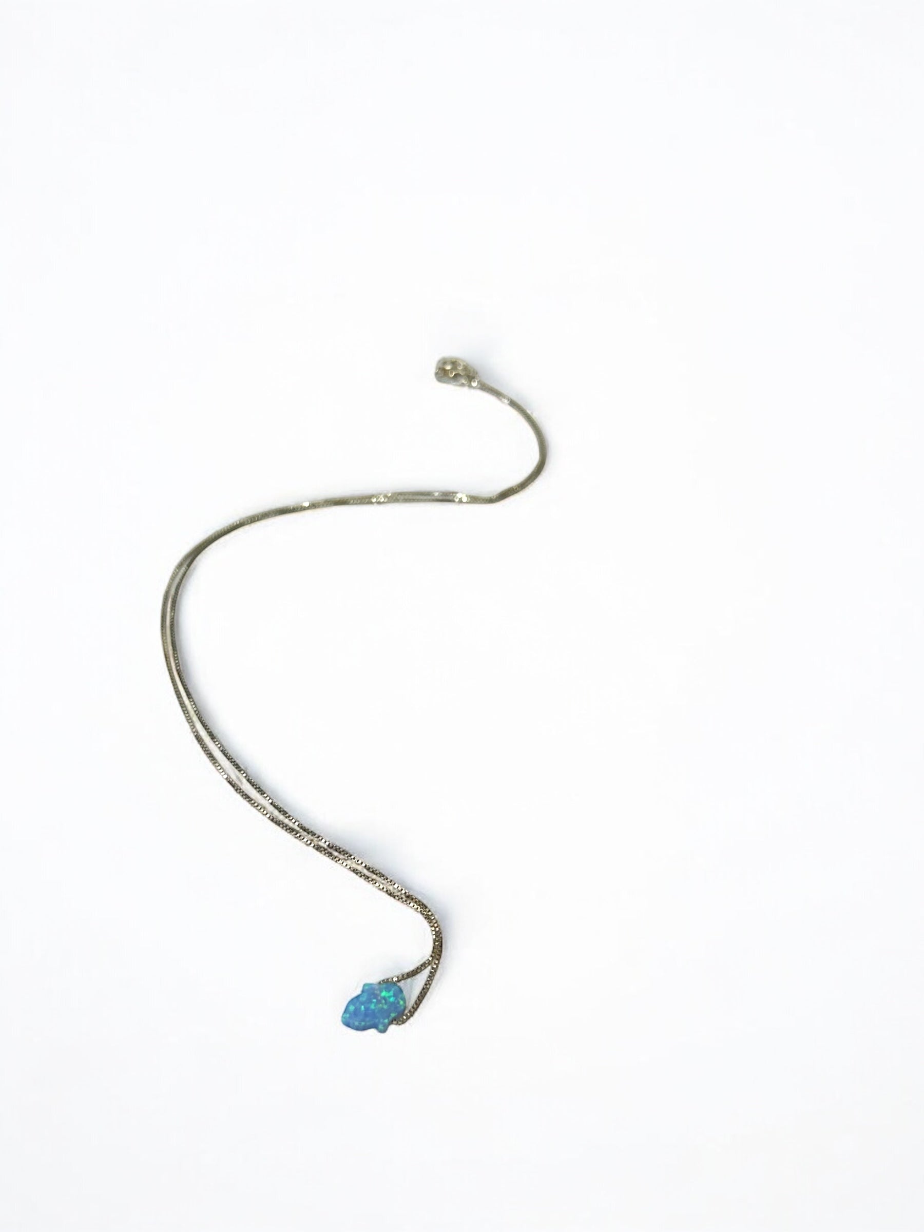 Close-up of hamsa hand shaped entirely from natural opal
