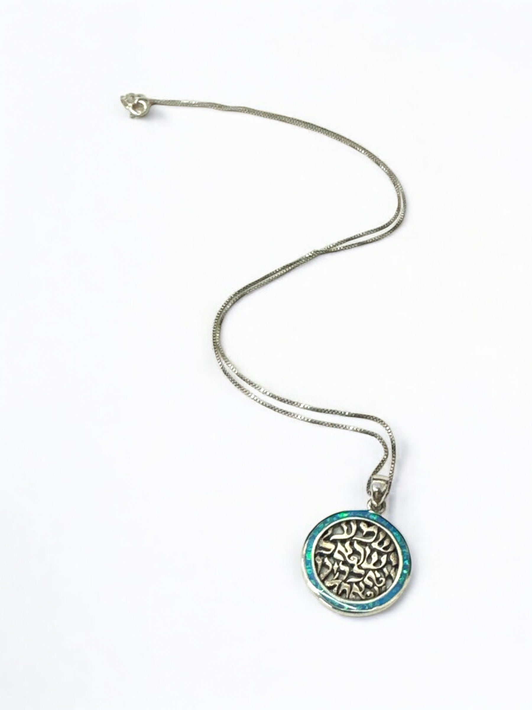 Close-up of Shema Israel Hebrew text and opal on medallion